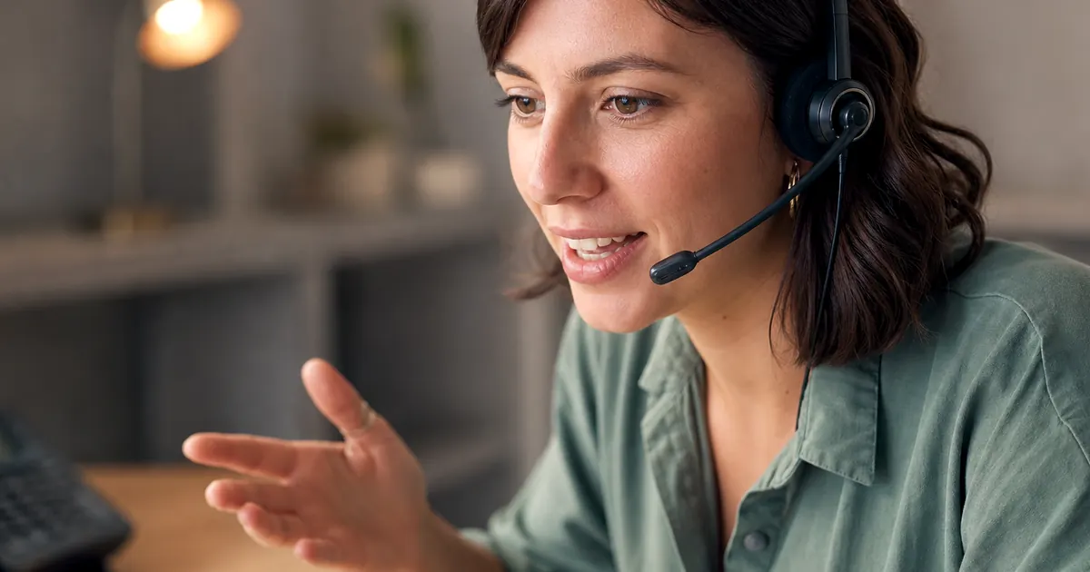 Insurance producer on another call while a second desk phone rings unanswered
